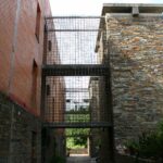 Fachada de piedra, acero, ladrillo y hormigón de una vivienda de obra nueva en Extremadura