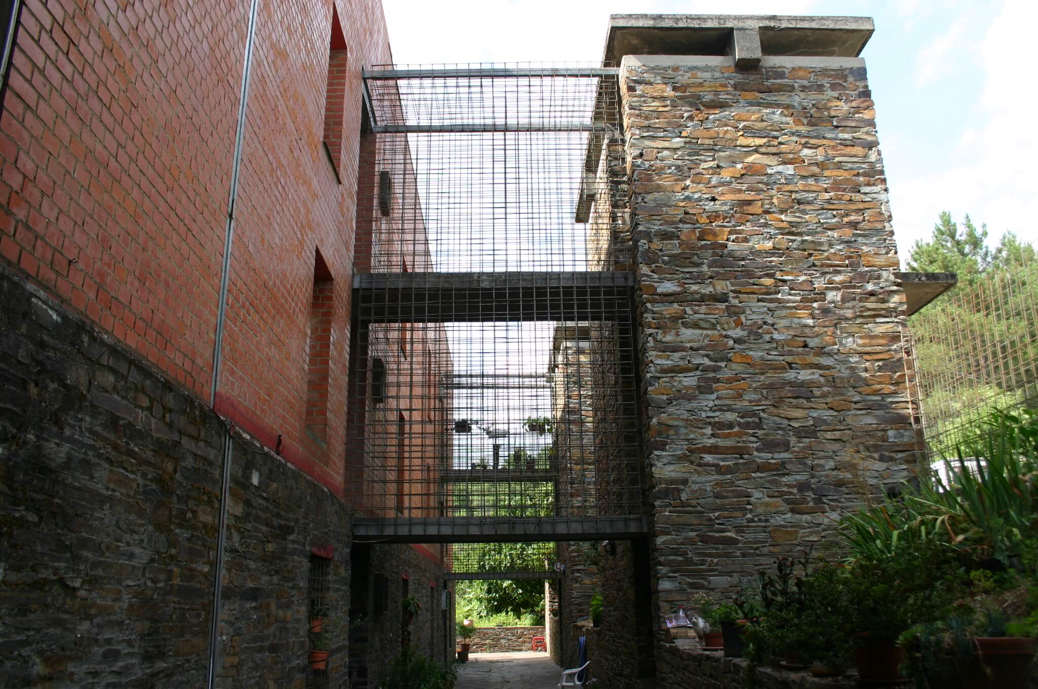 Fachada de piedra, acero, ladrillo y hormigón de una vivienda de obra nueva en Extremadura